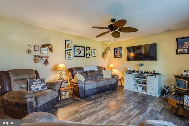 a living room with furniture a flat screen tv and kitchen view