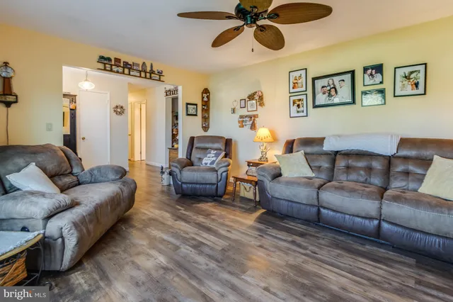 a living room with furniture and a ceiling fan