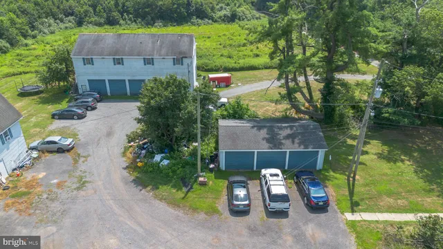 an aerial view of a house with swimming pool and large trees