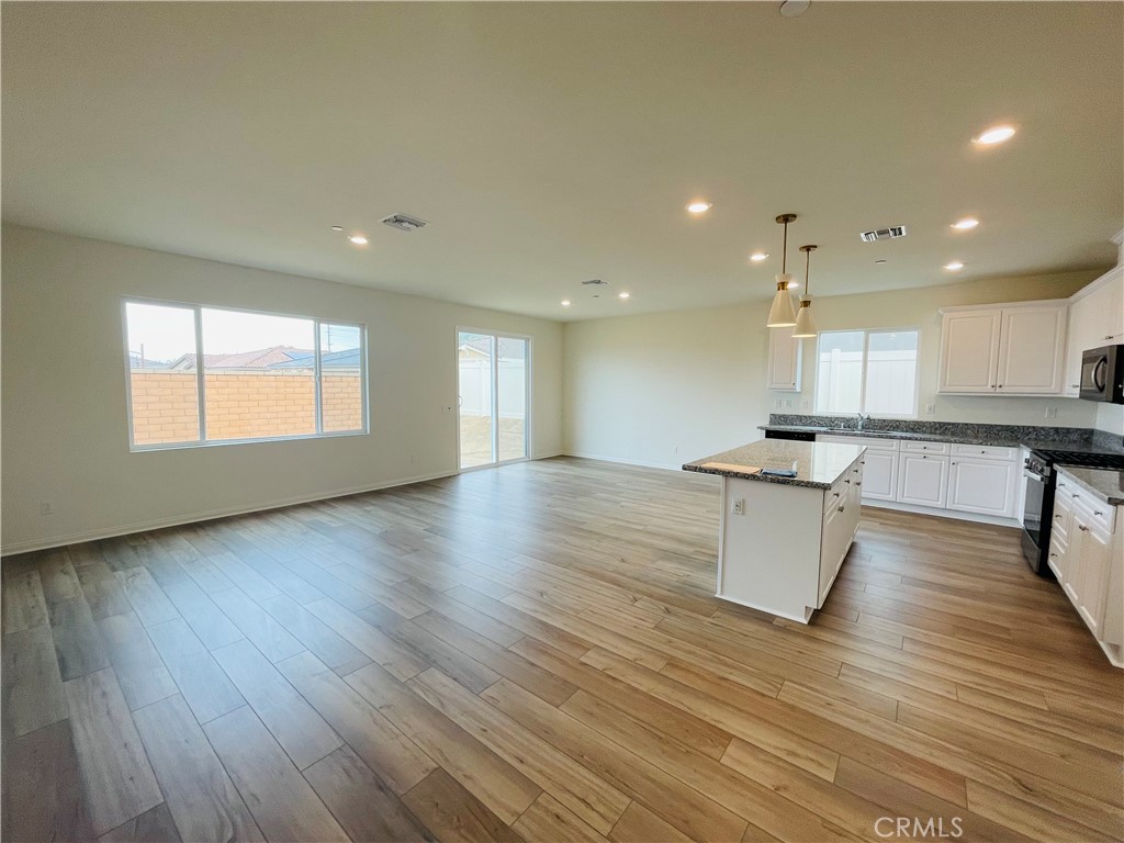 19770 Barnfield Place Riverside, CA 92507 - Photo 9 of 22 an open kitchen with white cabinets a sink and dishwasher