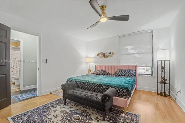 a bedroom with a bed and wooden floor