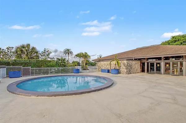 a view of a swimming pool with a yard and palm trees