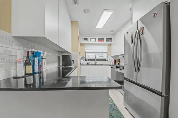 a view of a kitchen with stainless steel appliances granite countertop a refrigerator and a sink