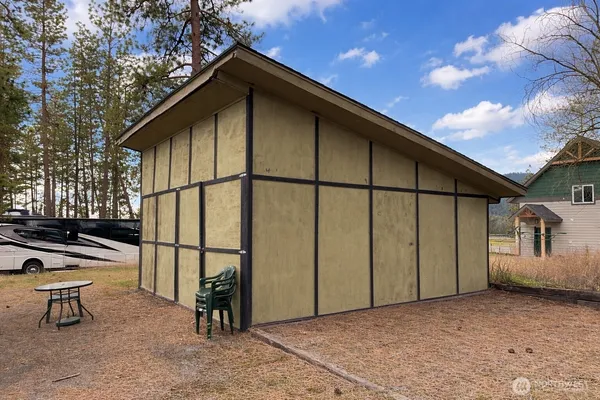 a view of a house with a small yard and a large tree