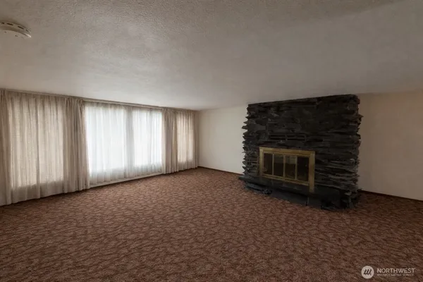 a view of empty room with a fireplace