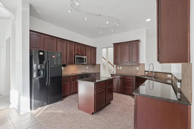 a kitchen with a stove a refrigerator and a sink