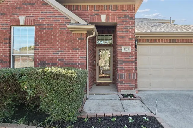 a view of a brick house with plants