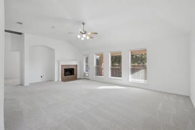 a view of an empty room with a fireplace and a window