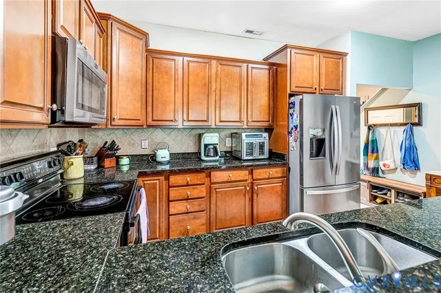 a kitchen with stainless steel appliances granite countertop a sink stove and cabinets