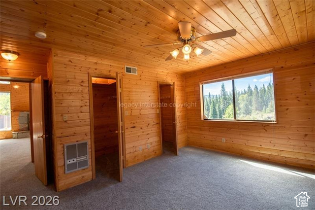 1129 Ponderosa Road, Unit 40 Hatch, UT 84735 - Photo 21 of 47 Wood-paneled walls and ceiling, wall-to-wall carpeting, ceiling fan with integrated lighting, and a large window showcasing tree scenery