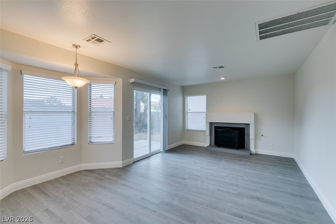 1738 Toltec Circle Henderson, NV 89014 - Photo 2 of 46 A fireplace warms this generously sized living area, featuring light wood-style flooring and natural illumination.