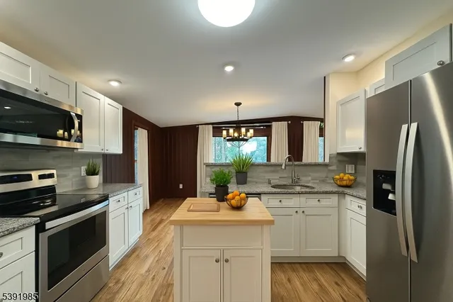a kitchen with a sink stainless steel appliances and white cabinets