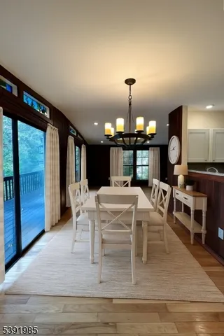 a living room with furniture a large window and chandelier