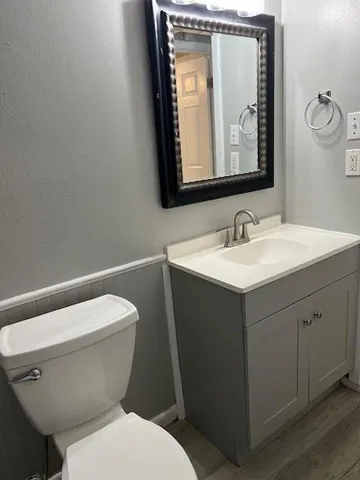 a bathroom with a toilet sink and mirror