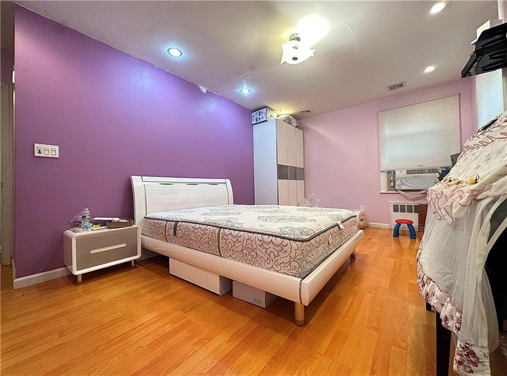1944 85th Street Brooklyn, NY 11214 - Photo 7 of 10 a spacious bedroom with a bed and wooden floor