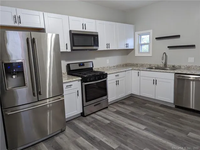 a kitchen with stainless steel appliances a refrigerator stove and microwave