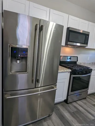 a metallic refrigerator freezer sitting inside of a kitchen