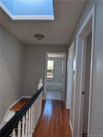a view of a hallway with wooden floor and stairs