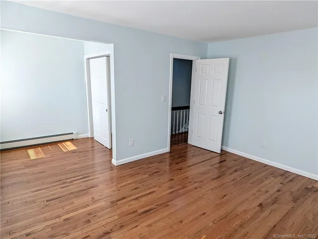 a view of an empty room with wooden floor