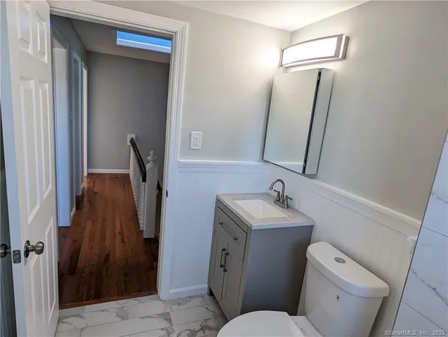 a bathroom with a toilet sink and mirror