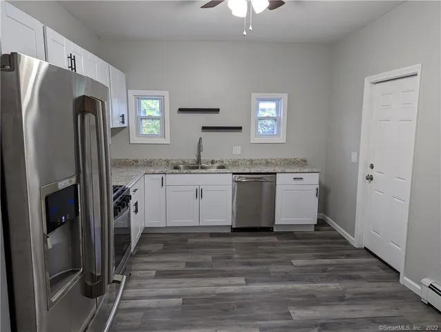 a view of a kitchen with a sink refrigerator and window