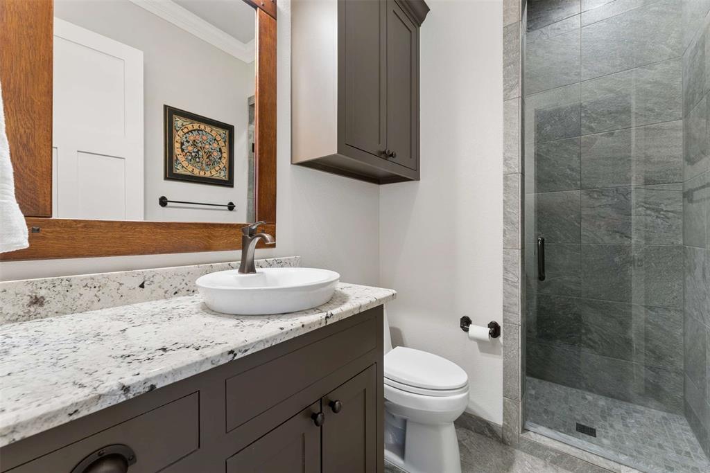 7430 Dawn Avenue Pilot Point, TX 76258 - Photo 18 of 39 a bathroom with a granite countertop sink a toilet and shower