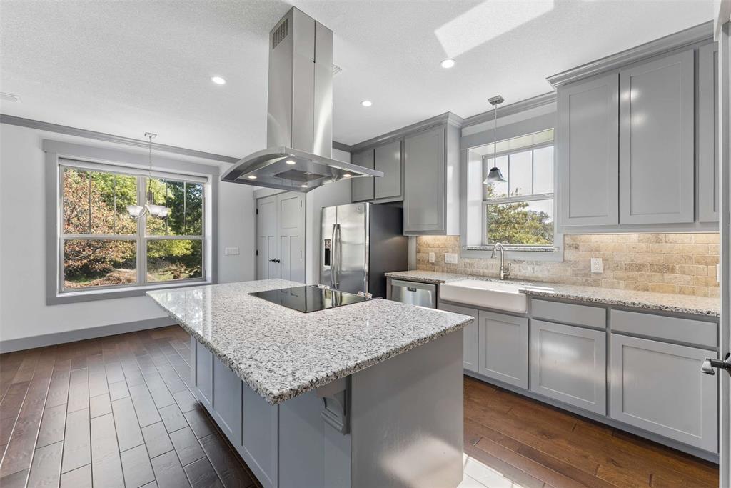 7430 Dawn Avenue Pilot Point, TX 76258 - Photo 26 of 39 a kitchen with granite countertop kitchen island a counter space a sink appliances and cabinets