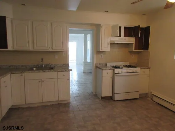 a kitchen with white cabinets and white appliances
