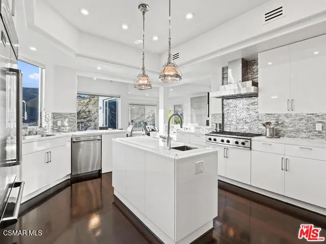 a kitchen with center island white cabinets and white appliances