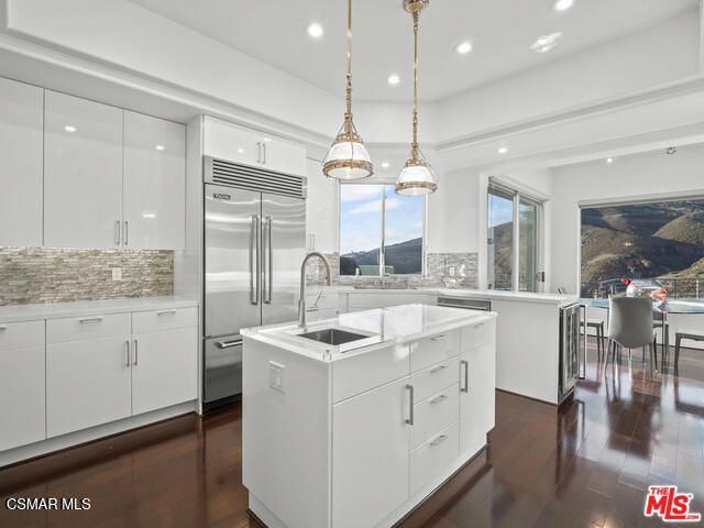 a kitchen with a refrigerator a sink and cabinets