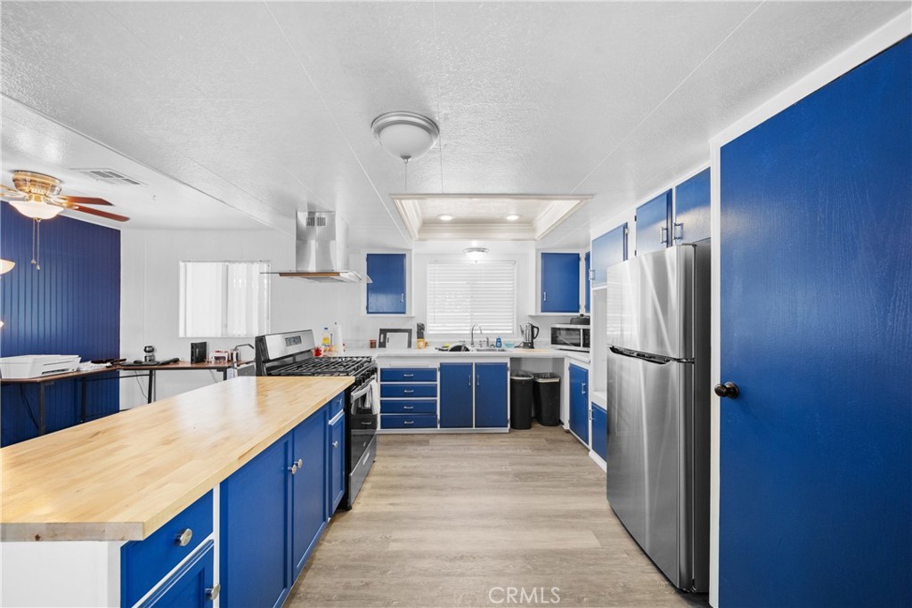 9391 California Avenue, Unit 56 Riverside, CA 92503 - Photo 15 of 45 a large kitchen with stainless steel appliances granite countertop a refrigerator a sink dishwasher a stove and a refrigerator