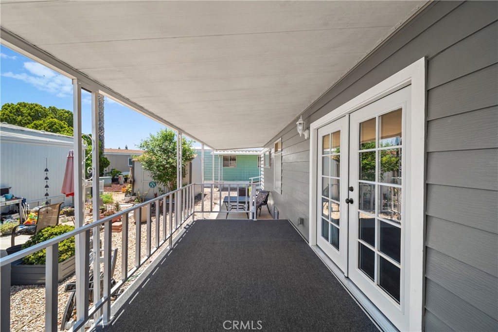 9391 California Avenue, Unit 56 Riverside, CA 92503 - Photo 5 of 45 a view of a porch with wooden floor and iron fence