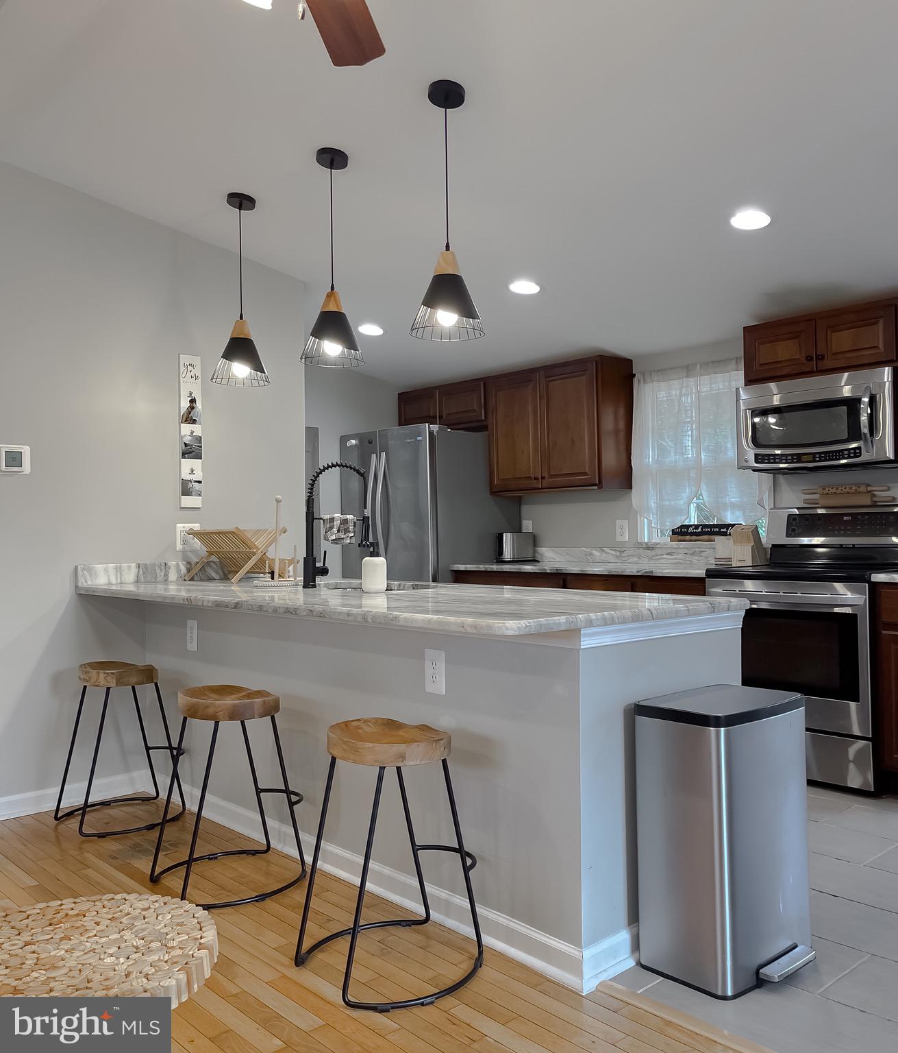 12028 Double Tree Lane Lusby, MD 20657 - Photo 11 of 40 a kitchen with stainless steel appliances granite countertop a stove a sink and a refrigerator