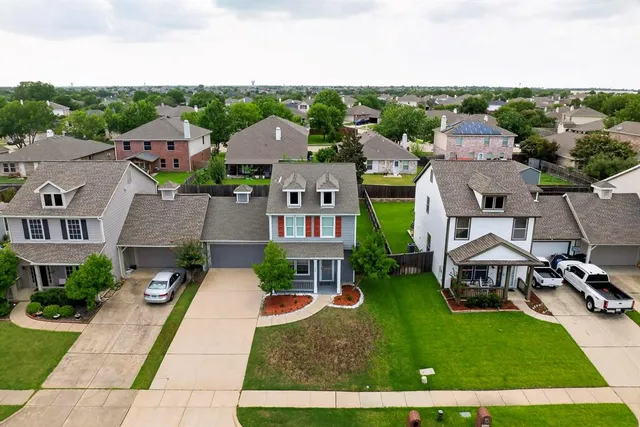 an aerial view of multiple houses with a yard