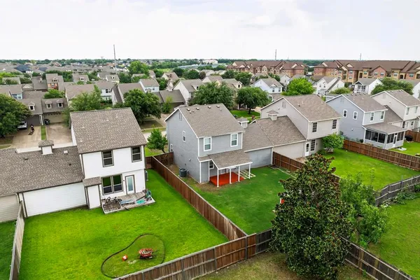 an aerial view of residential houses with outdoor space and trees