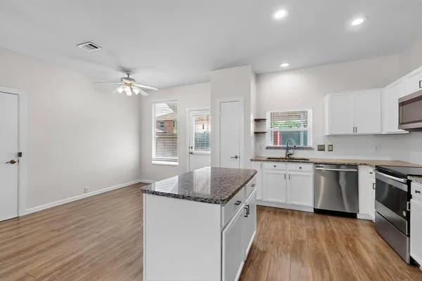 a kitchen with stainless steel appliances granite countertop a sink stove and refrigerator