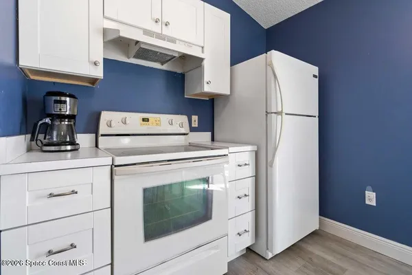 a kitchen with stainless steel appliances white cabinets and a refrigerator