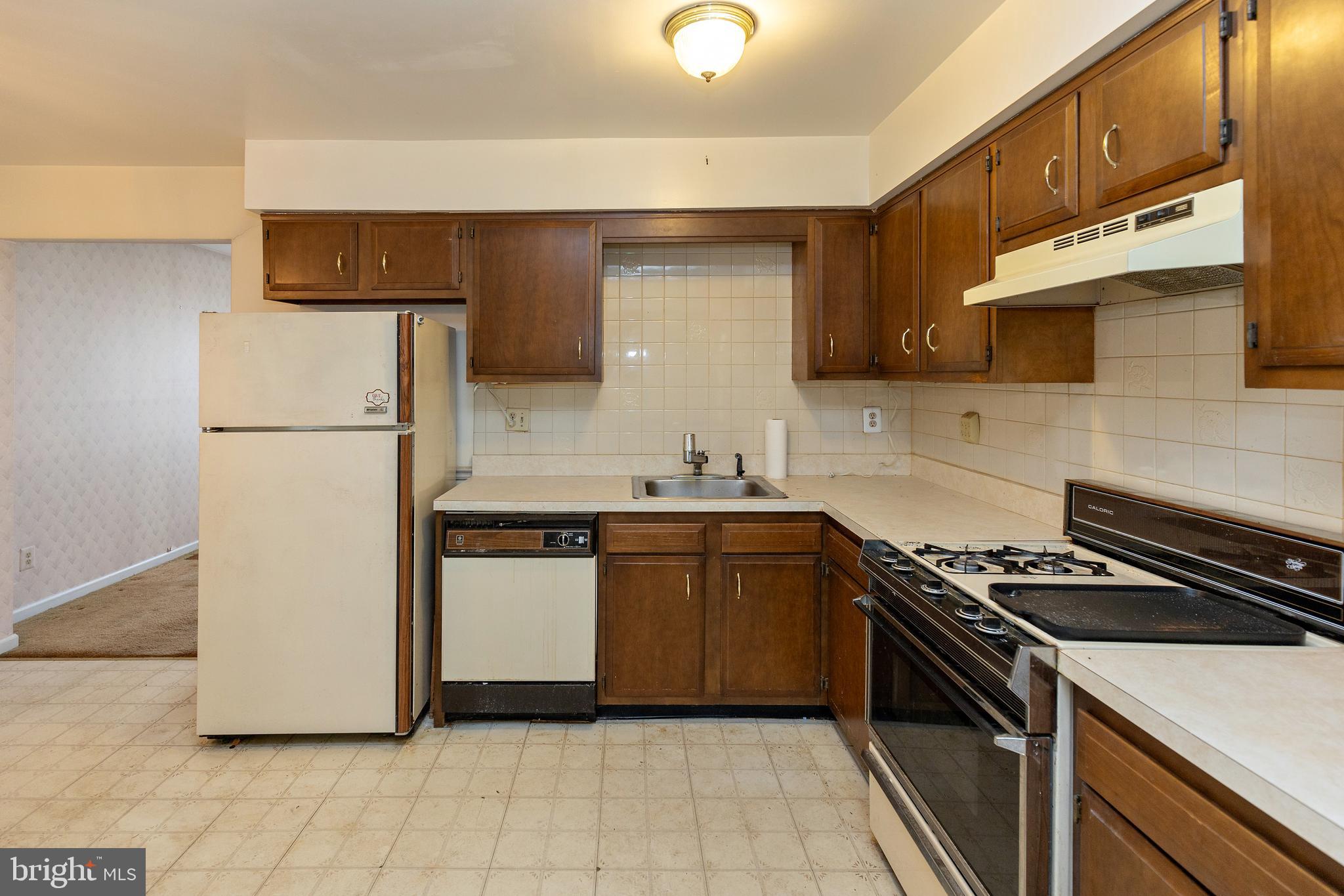 322 West Washington Avenue Magnolia, NJ 08049 - Photo 6 of 28 a kitchen with a sink a stove and refrigerator