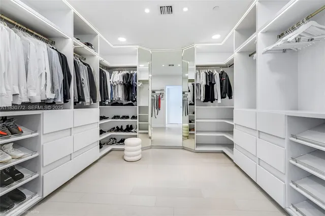 a view of walk in closet with clothes and shoes