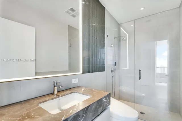 a bathroom with a granite countertop tub sink and mirror