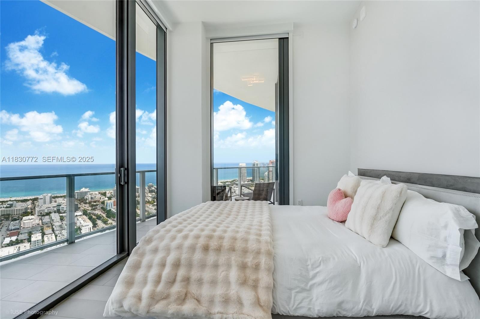 500 Alton Road, Unit 4401 Miami Beach, FL 33139 - Photo 18 of 34 a bedroom with a large window and a bed