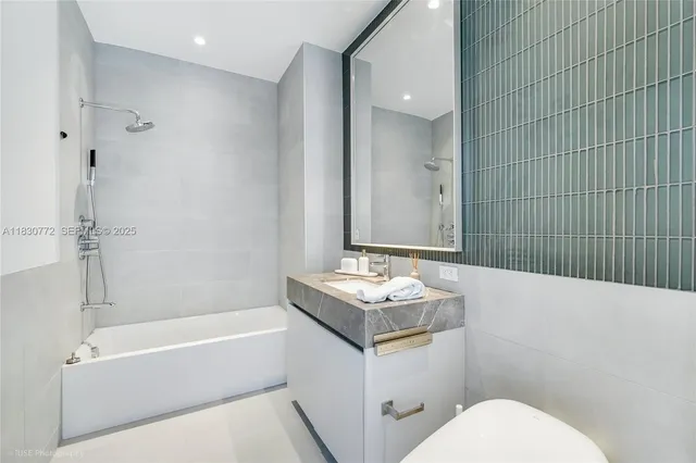 a bathroom with a sink toilet vanity and shower