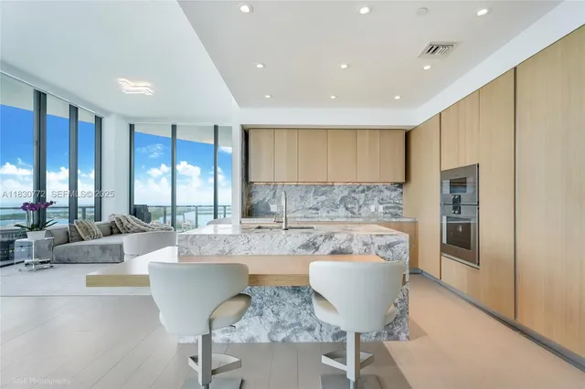 a large kitchen with a large window and stainless steel appliances