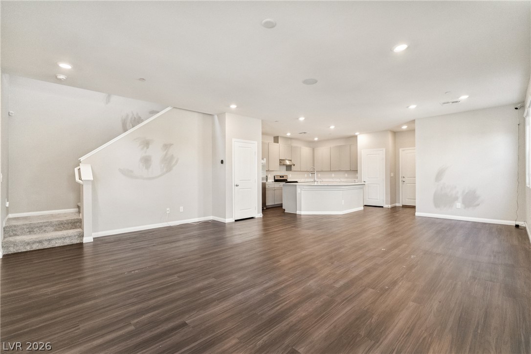 Rich wood-inspired floors anchor this airy, open-concept living area and kitchen.