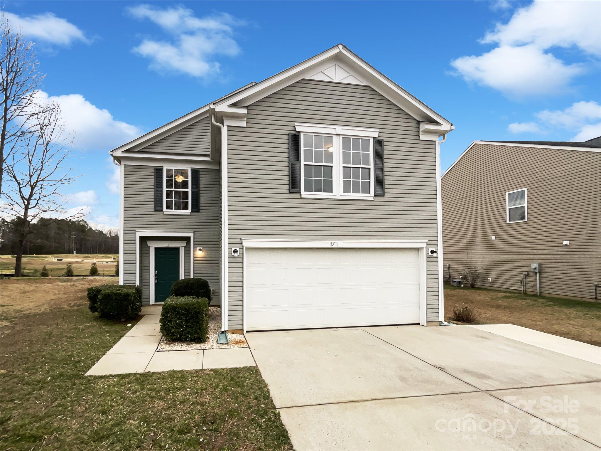 a view of a white house with a yard and plants
