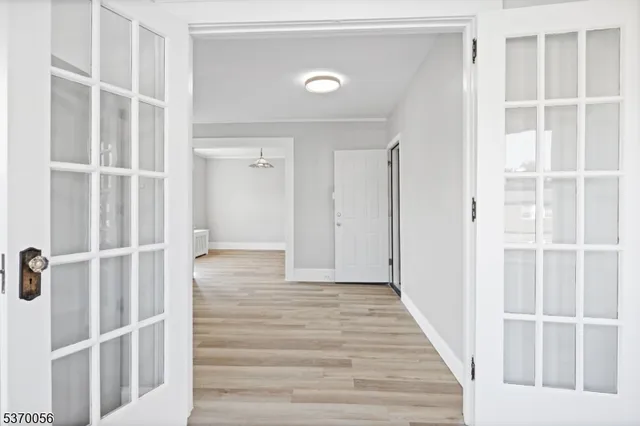 a view of a hallway with wooden floor and closet