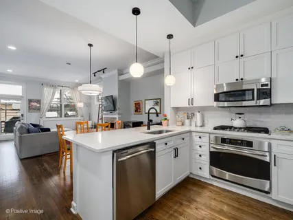 a kitchen with a stove cabinets and wooden floor