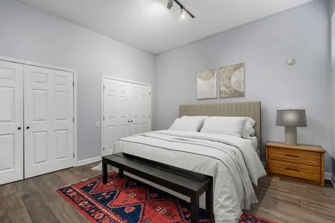 a bedroom with a bed and a lamp on the dresser