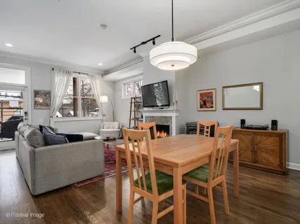 a view of a dining room with furniture a fireplace and wooden floor