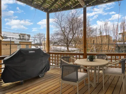 a balcony with wooden floor table and chairs